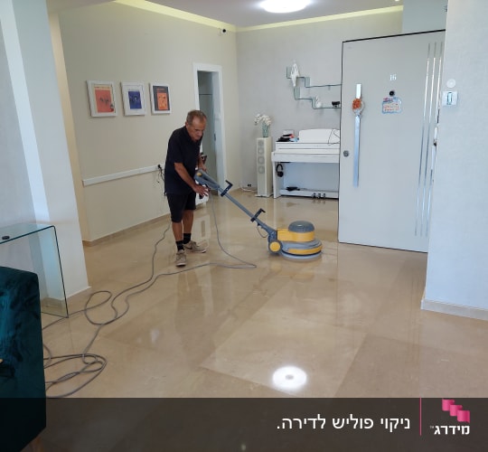 אדם מנקה רצפה עם מכונת פוליש חשמלית